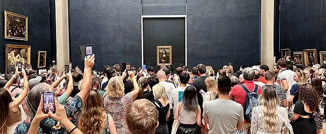 Crowd looking at the Mona Lisa through smartphone screens